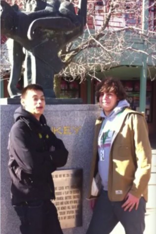 Sam lee and Grayson Zubradt stand in front of the monkey zodiac sculpture in Chinatown square.