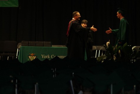 Graduate Ryan Doyle receives his diploma after giving a heartfelt speech earlier in the ceremony.   