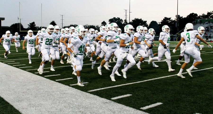 The York football team gets pumped for the game as they run onto the field.