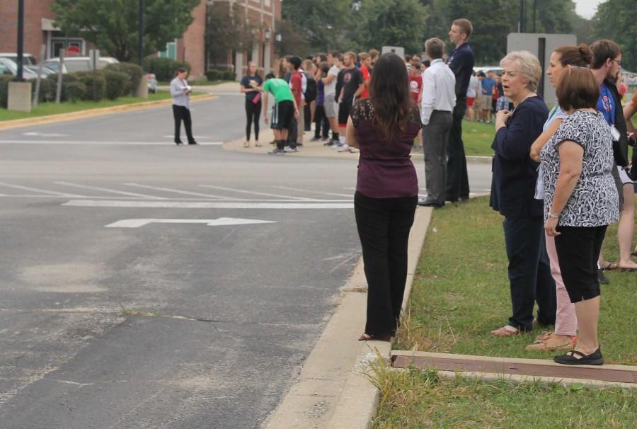 Teachers wait with their classes during fire alarm evacuation.
