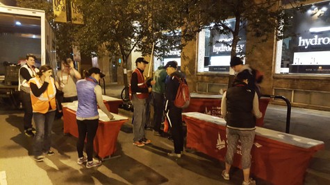 Volunteers at the 5k distance marker organize the set up of fluid tables.