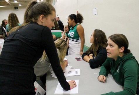 Varsity cheerleading coach, Emily Martin, encourages an 8th grader to join the team next year.