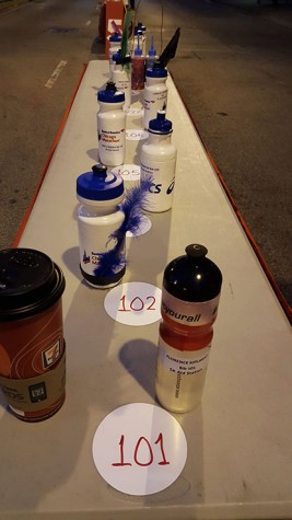 A volunteer's early morning coffee can be seen along side the unique bottles of the elite racers.