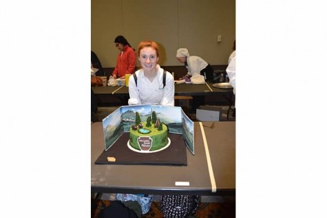 Junior Samantha Flesh stands proudly next to her National Park Service themed cake after her presentation had ended.