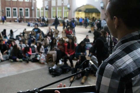 Senior Eli Delgado preforms in front of a crowd of students during Mondays open mic of Fine Arts Week.