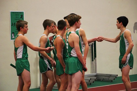 Two teams of York runners shake hands before competeing against each other in the 4X800m relay.