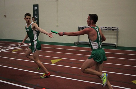 Ed Liebeno, senior, hands off the baton to Max Albers, sophomore, in the varsity 4X800m relay.