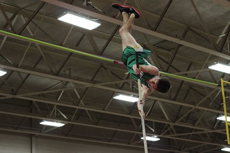 Ethan Kett, senior, clears the bar while pole vaulting in the away meet hosted by Proviso West High School.