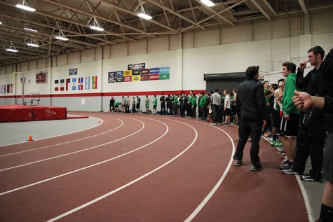 The team lines the curve during the last race, the 4x400m relay, in preparation to cheer on the runners.