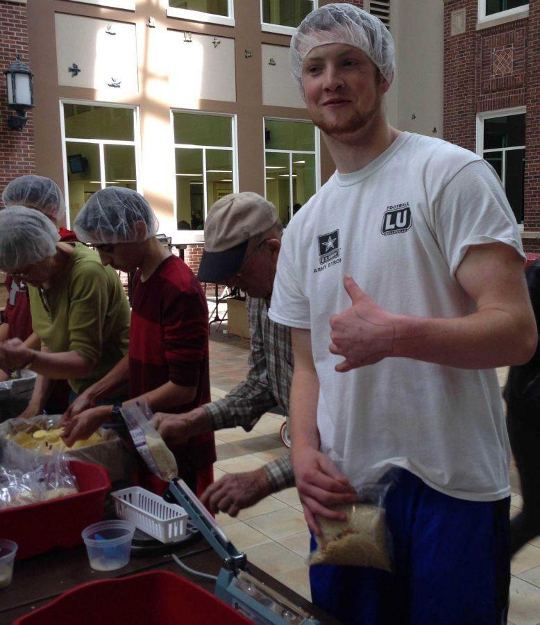 Junior Chris McCoy volunteers to seal rice bags for starving children in the Food Fight event.