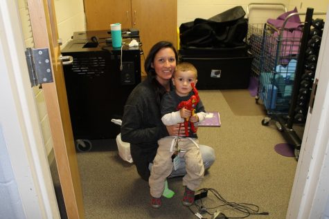 Yoga teacher Ms. Munn holds her son Chance while he plays with an action figure. 