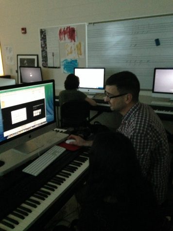 Mr. Pavlik (right) helps a student (left) with a composition