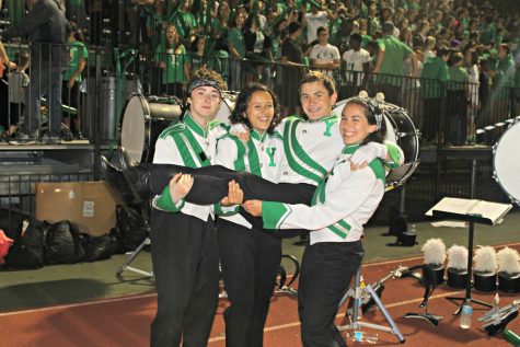 Marching band members Becky Scheibl, Joie Pecoraro, and Mollie Grasse, carry fellow member Nick Thomas to celebrate this year's half-time show.