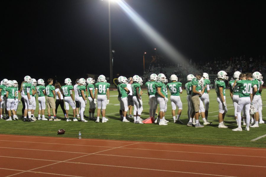 Varsity football players waiting for a play in the second half to begin.