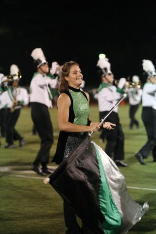 Natalie Rohman, senior, smiles to the crowd as she performs "Crazy Little Thing Called Love" at the homecoming football game.