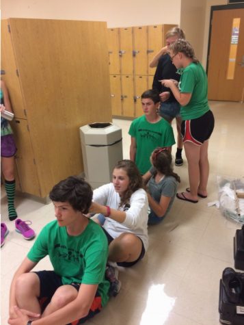 Prepping for the first game, Sam Griffen, junior, Kaitlin and Abril Stoddard, sophomores, Nick Thomas, senior and Emily Rohman, sophomore, create a train to braid each others hair. 
