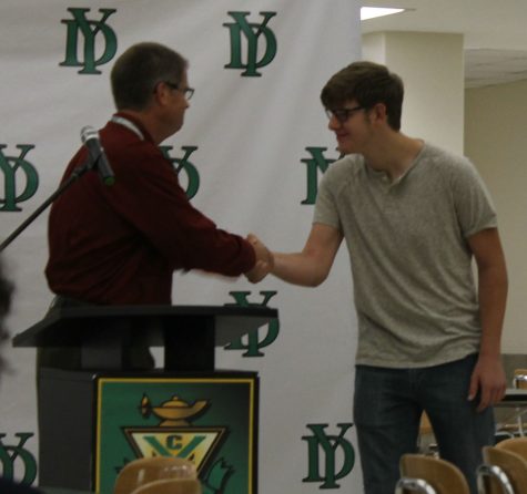 Senior Michael Ryan proudly accepts the honor of Student of the Month for Performing Arts from Mr. Bill Riddle, who praised his enthusiasm as a music student and member of the band.