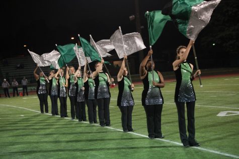 Performing their pregame routine at the homecoming football game, the color guard shows off their skills with the "Fight Song" choreography.