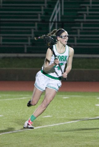Zoe Lawless cradles the lacrosse ball as she runs up the field.