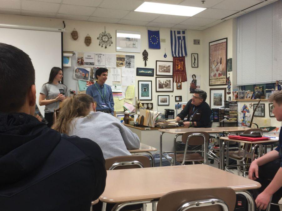 Club executive members junior Anne Grasse and senior John Clugg talk with Mr. Gearing during a club meeting.