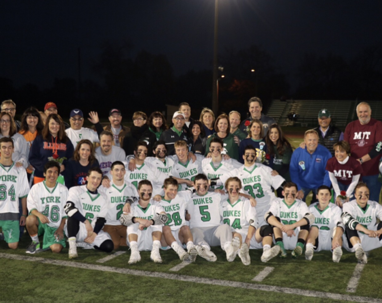 Senior lacrosse players and all of their parents stop for a picture at senior night on Tues., May 9 at the York Stadium. Some parents even sported shirts of where their sons will be attending college next fall.