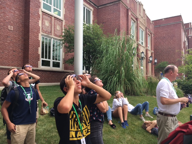 Students borrowed Mr. Blauss [far right] glasses to safely watch the eclipse. 