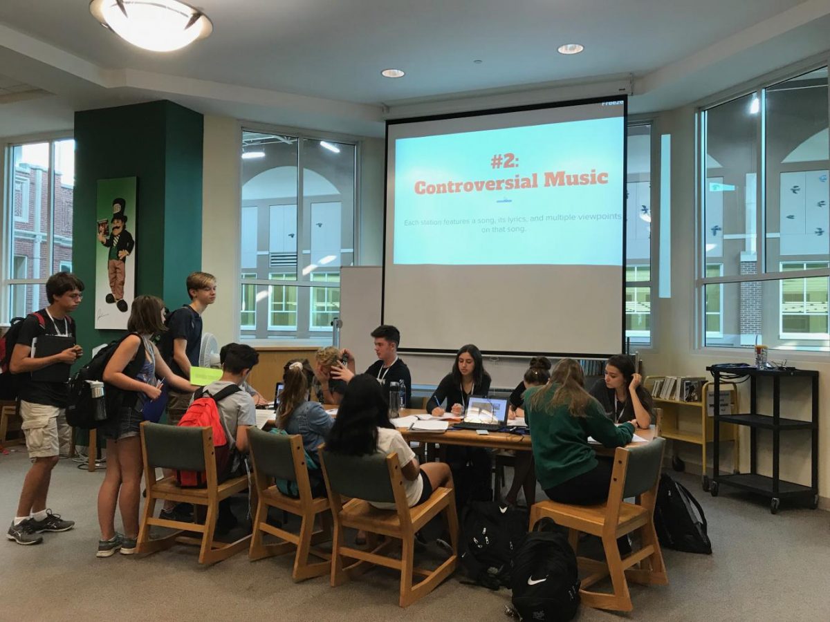 Sophomore students gather around laptops to listen to controversial music in the Ellis Room for the Constitution day forum. Sept. 26, 2017.