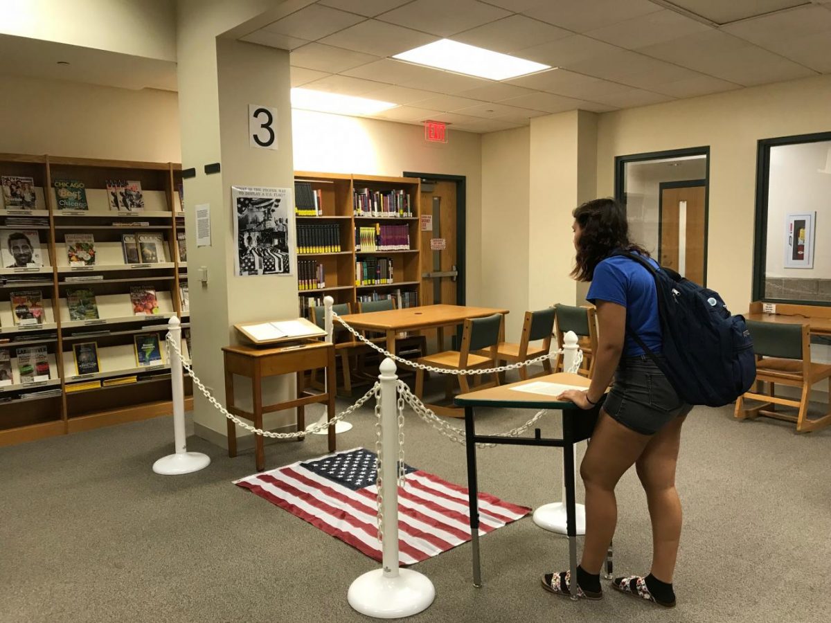 Sophomore Emily Belcher looks at Dread Scotts What is the Proper way to display a U.S. Flag? in the York Learning Commons Tuesday morning. Sept. 26, 2017.