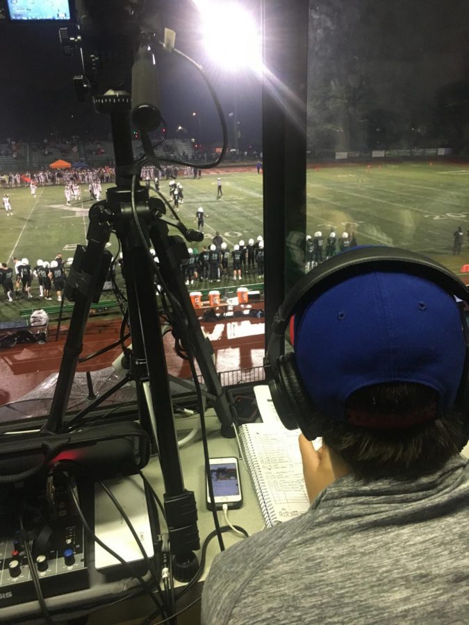 Senior Sam Deuter watches the game while taking notes and announcing play-by-play to his online audience.