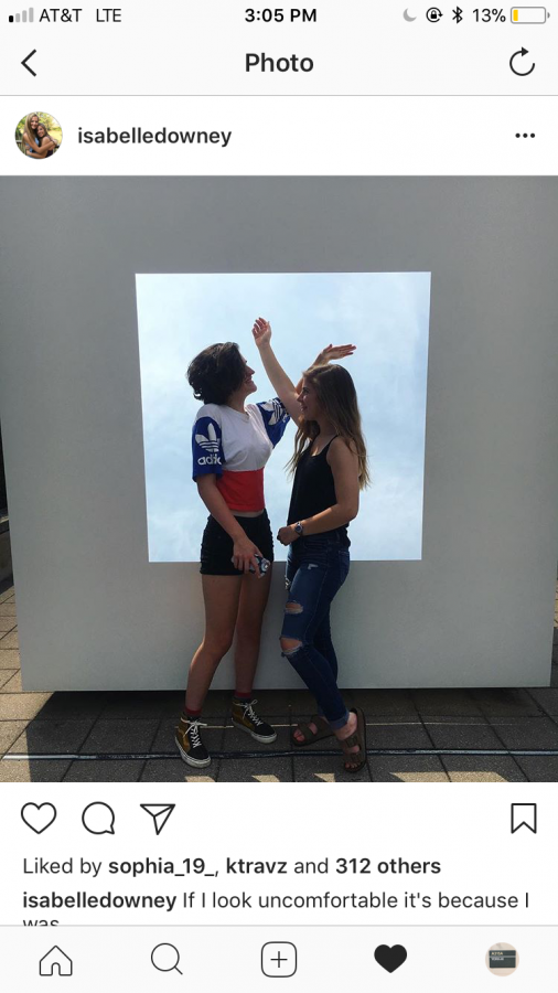 Senior Eileen King (left) and Junior Isabelle Downey  take a candid picture in front of Haskins Skycube.