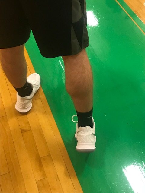 Senior varsity basketball  player models his calf in hope to win the Turkey Leg Contest.
