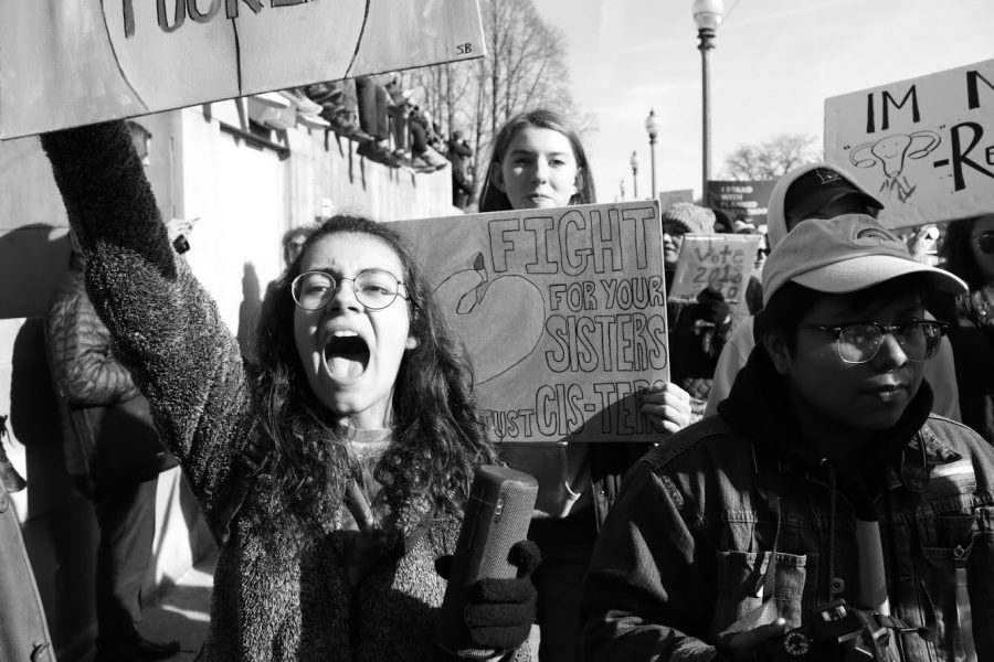 York alum Sam Barton (left), passionately holding up her sign and a Bluetooth speaker playing Titanium, is joined by Junior Parker Mahoney (right) as they march together at the 2018 Womens March. Sat., Jan. 20, 2018