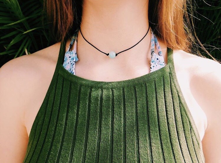 Sophomore, Abby Moriarty, artfully poses for a picture to display one of her handmade necklaces during a vacation to Florida for her businesss Instagram followers. Dec. 30, 2017