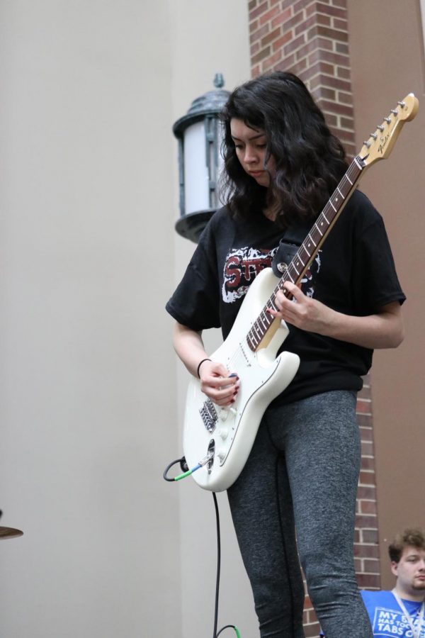 Junior __ plays the guitar during her bands performance of __. 
