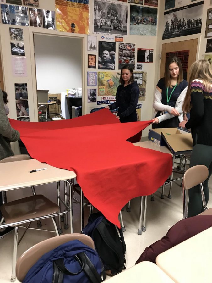 Members of EMPOWER measure out red felt for the creation of red Vs for V-Day. 