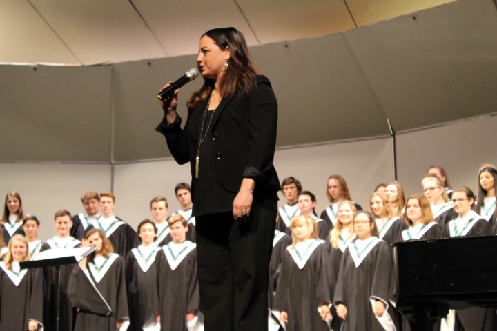 Choral+director+Rebecca+Marianetti+speaking+to+parents+about+the+next+piece+in+the+concert.