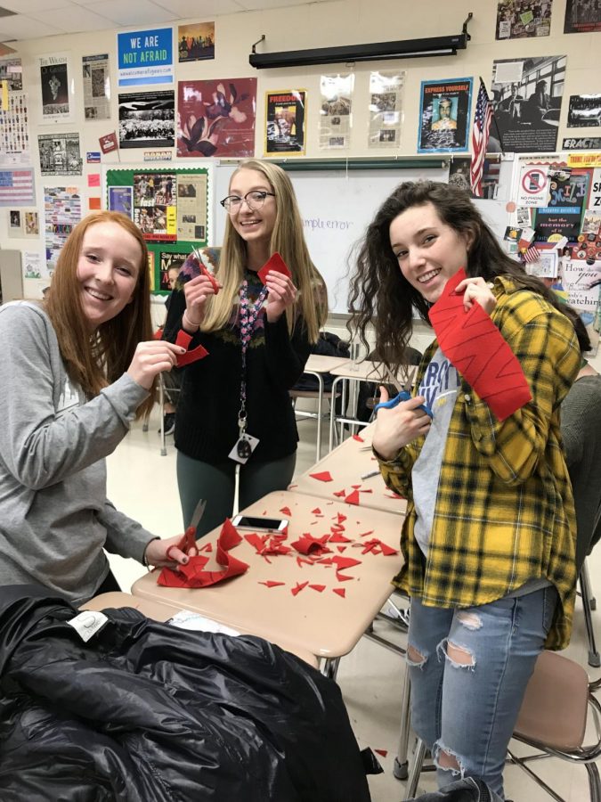 Seniors Sarah Sullivan, Isabella Young, and Claudia Todd present the red Vs they worked on for V-Day. 