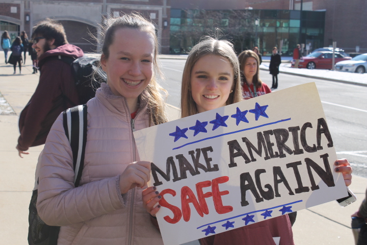 Freshmen Anna Drewno and Gia Stephan hold up a sign that plays on the Make America Great Again slogan. 