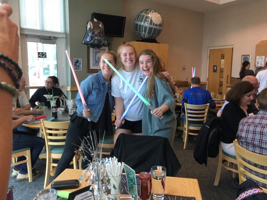 From left to right, Seniors Julia Johnson, Stephy Tompos, and Cambira Khayat pose with light sabers during luncheon on Friday May 4, 2018. 