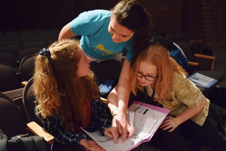 Sophomores Jillian Caforio, Meagan Maiers, and Olivia Rosenberg study the scene before taking the stage.