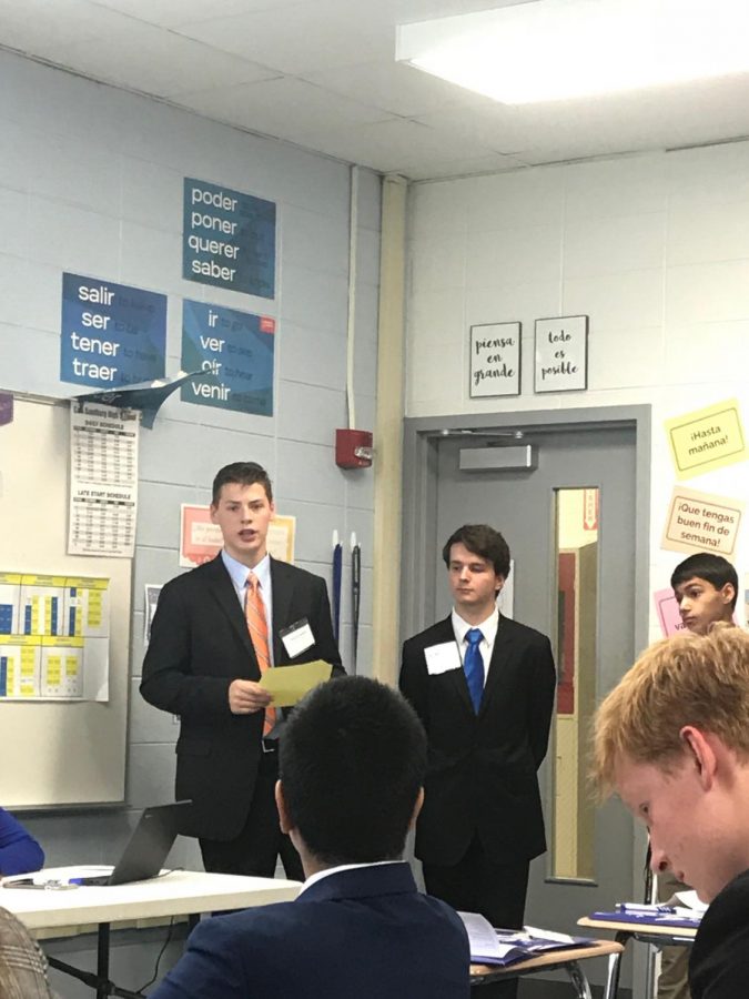 York delegate Aaron Ludkowski, center, stands as a fellow delegate introduces a resolution paper. 