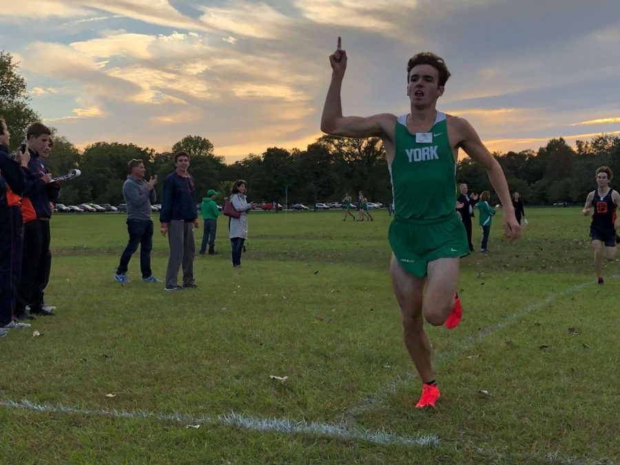 Junior Will Yasdick celebrates his first place individual finish racing at Schiller Woods against OPRF and Hinsdale Central. Photo courtesy of Charlie Kern.