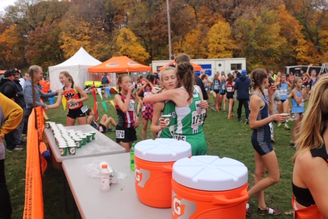 Freshman Kathleen Buhrfiend and junior Grace Moriarty hug after completing their races at Detweiller Park.