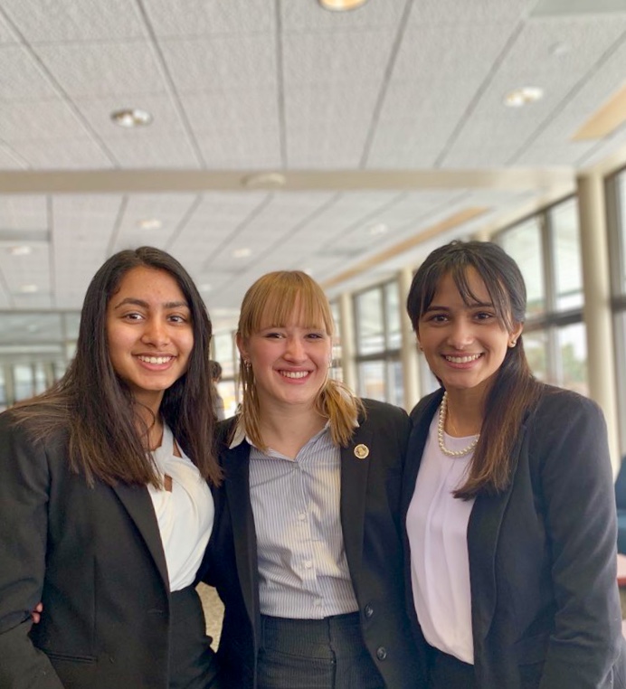 Law team captains Maya Iyer, Katherine Clugg, and Lexiene Lukose pose victorious after placing top eight at an invitational. 