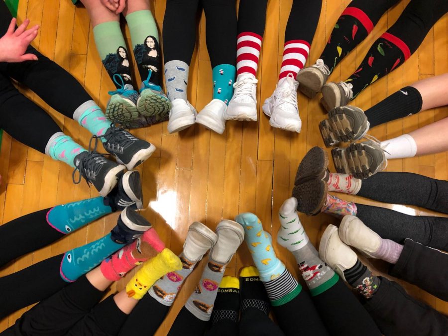 The PE Leaders class take a picture of their crazy, mismatched socks before starting class.