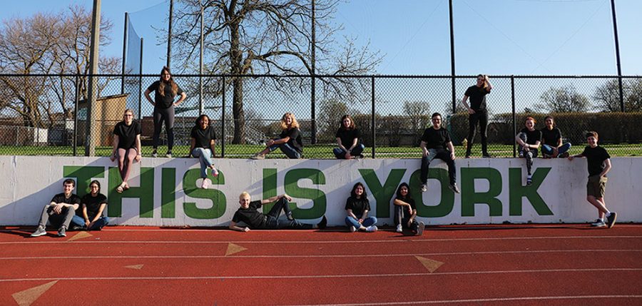 Seniors from York-his cover shoot pose on the THIS IS YORK sign on the field. 