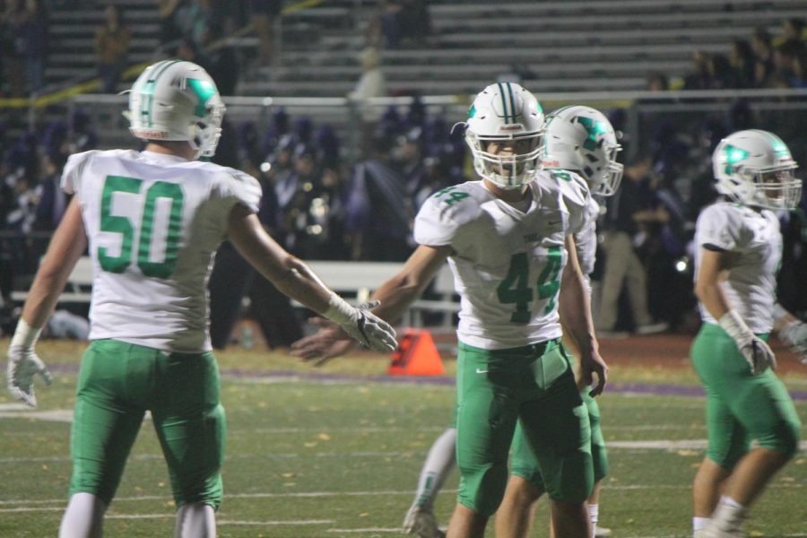 Seniors Liam Enright (50) and Chris Eckard (44) dap each other up after making a big play.