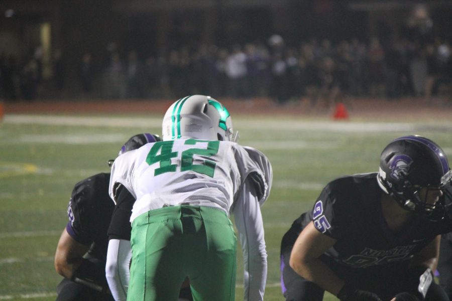Senior Sean Maher (42) sits on the line of scrimmage awaiting the snap.
