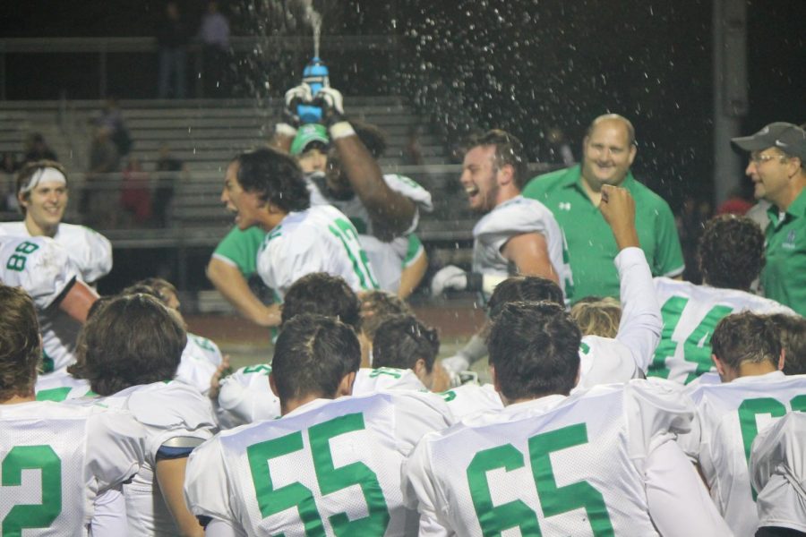 Senior Josh Mathiasen (66) sprays water over the huddle in celebrate of the teams victory.