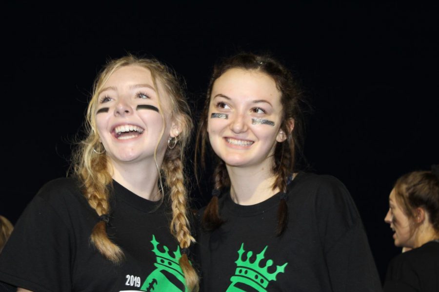 Seniors (from left) Cece Spirakis and Erin Quaid smile as they look onto the field. 